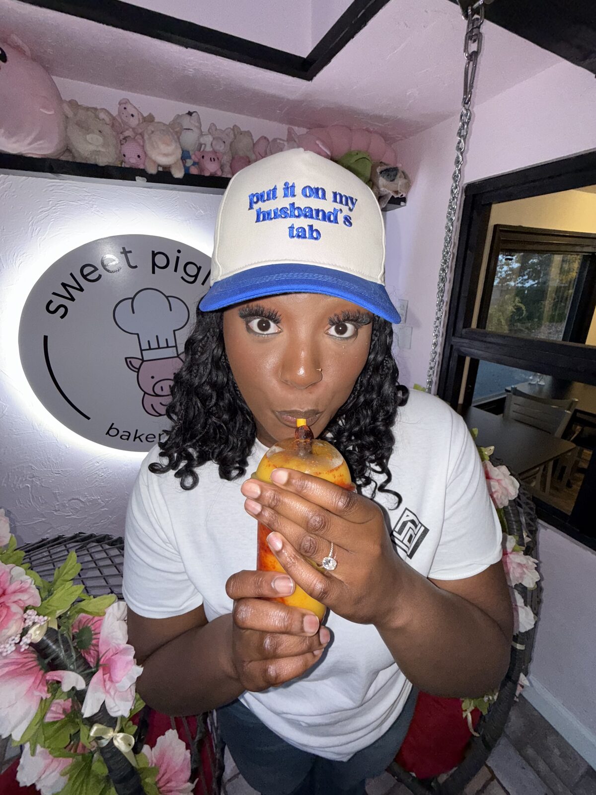 Fikayo sipping a spicy mango drink at Sweet Piglet bakery